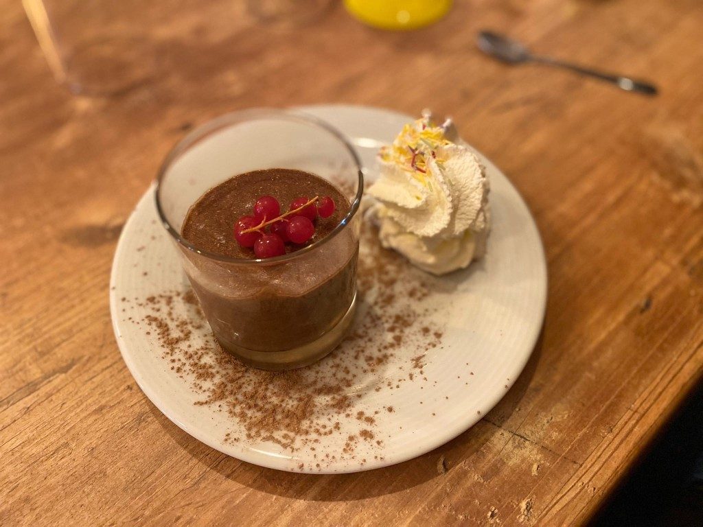 Un dessert au chocolat avec de la chantilly et des framboises